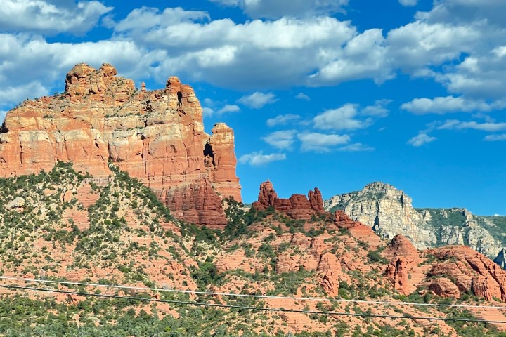 Red rock formations under a blue sky with scattered clouds.