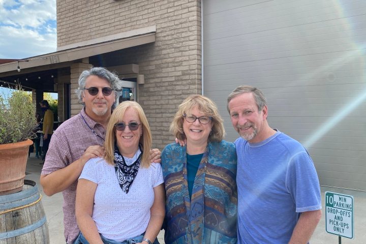 Four people stand smiling outside Chateau Tumbleweed winery.