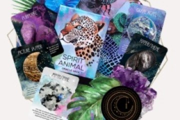 Assorted spirit animal and crystal reading cards arranged with leaves and a circular chart.
