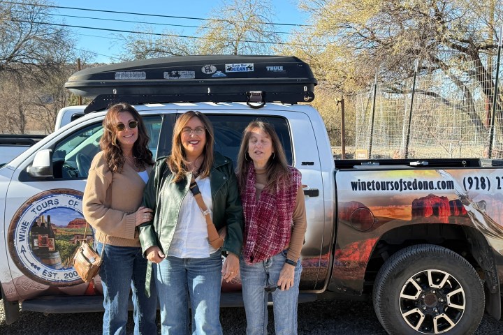 Three people standing in front of a truck with 'Wine Tours of Sedona' branding.
