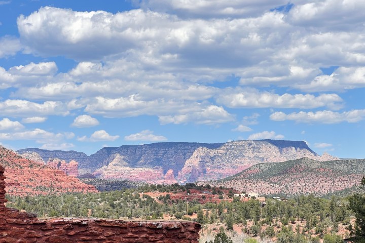 Red rock landscape with blue sky and scattered clouds in the background.