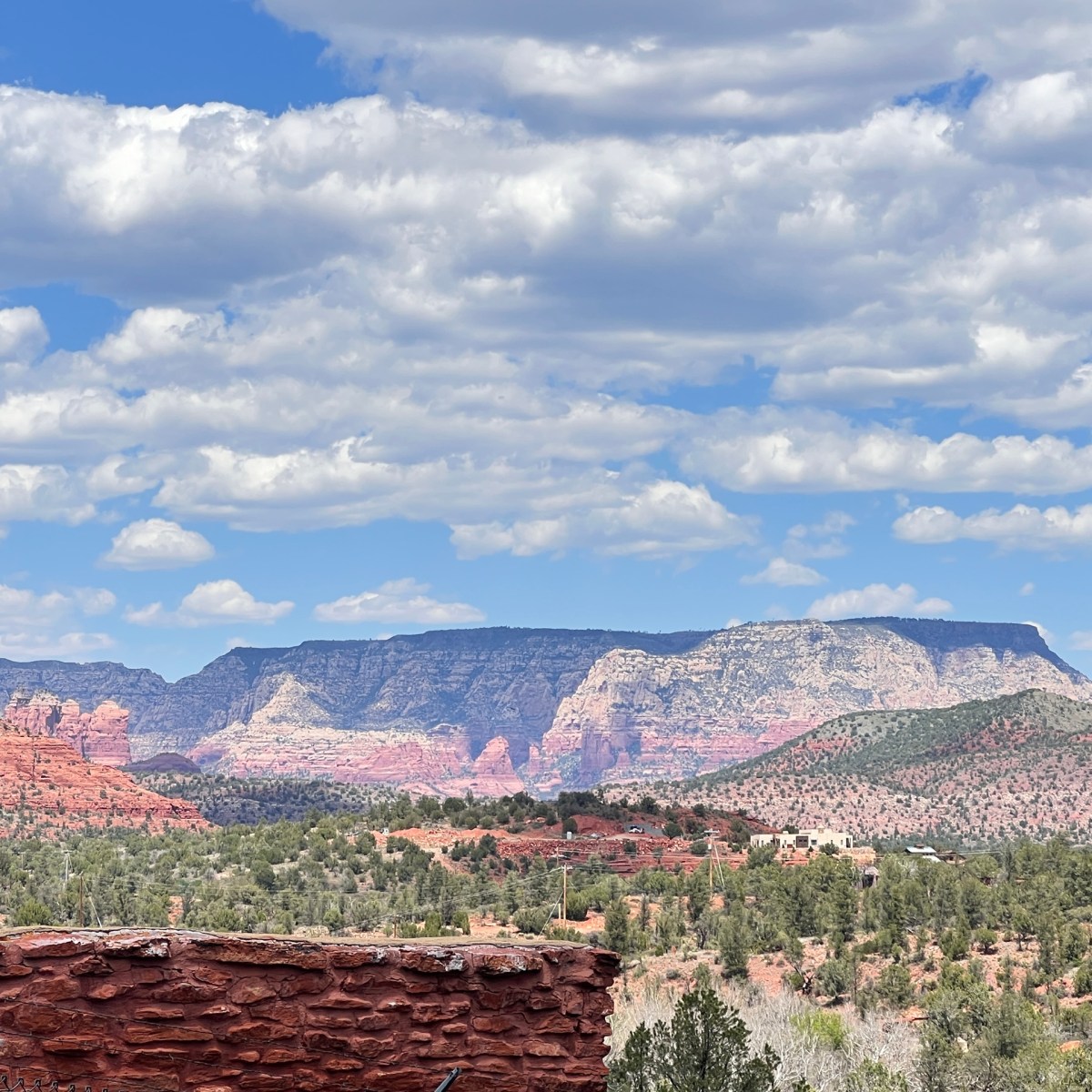 Red rock landscape with blue sky and scattered clouds in the background.
