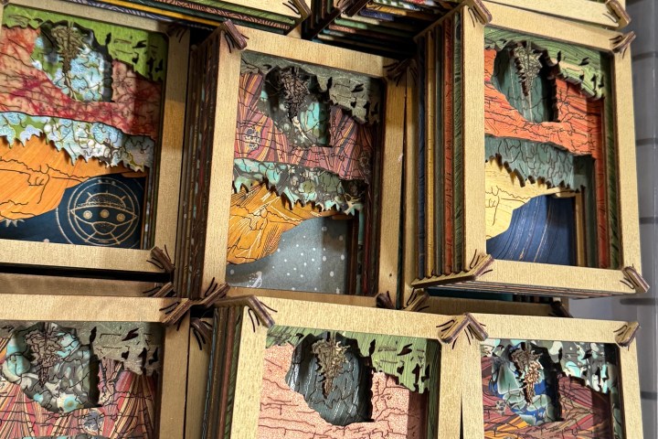Stacked artsy boxes with colorful abstract designs in a plastic container.