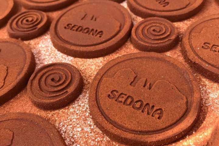 Close-up of brown circular tiles with the word 'SEDONA' and spiral patterns.