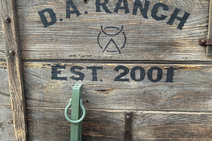 Wooden wagon sign with 'D.A. Ranch Est. 2001' and a logo, metal latch at center.