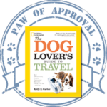 Book cover: 'The Dog Lover's Guide to Travel' with a blue stamp saying 'Paw of Approval'.