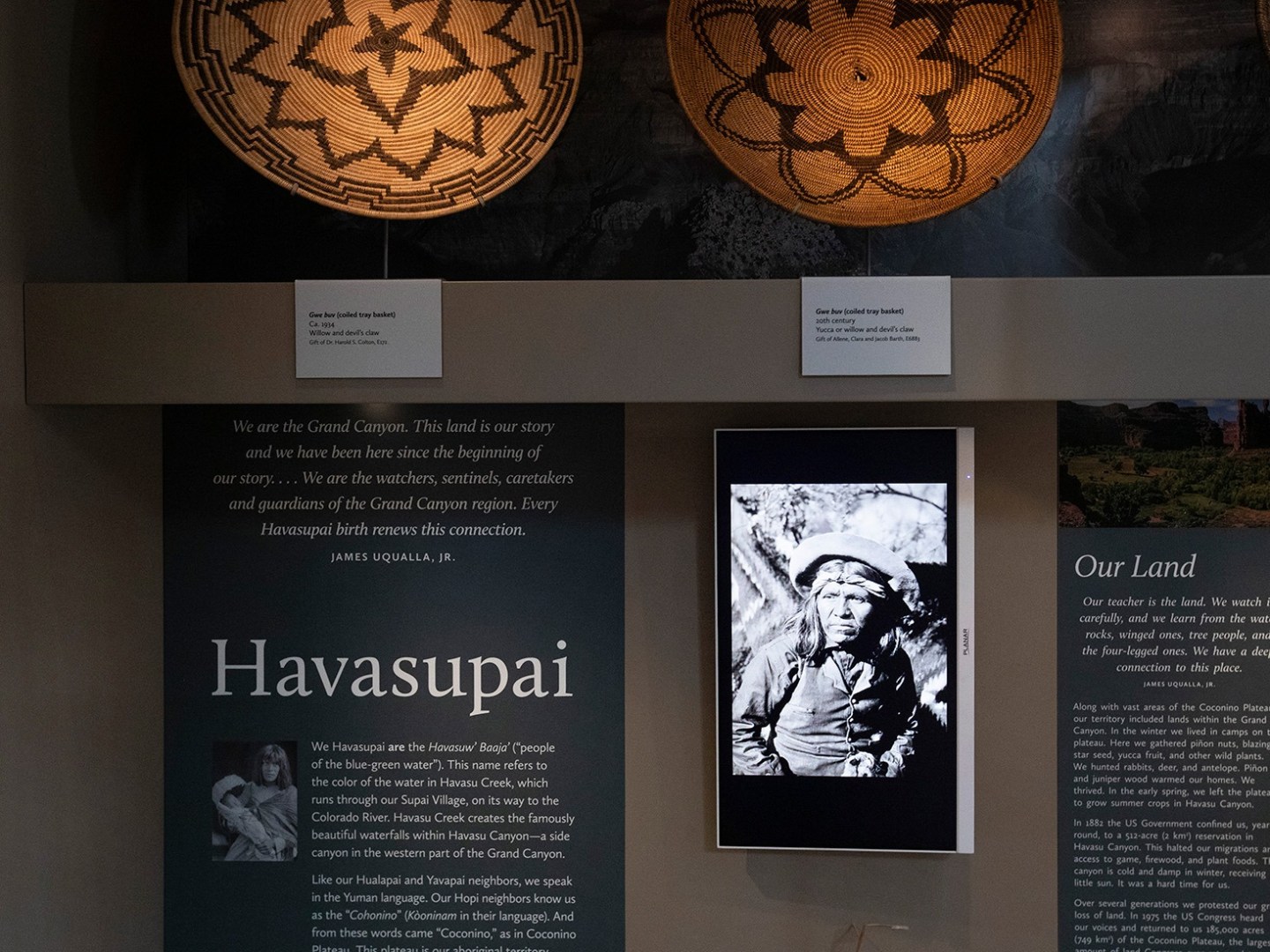 Display with Havasupai text, woven baskets, and a black-and-white photo of a man.