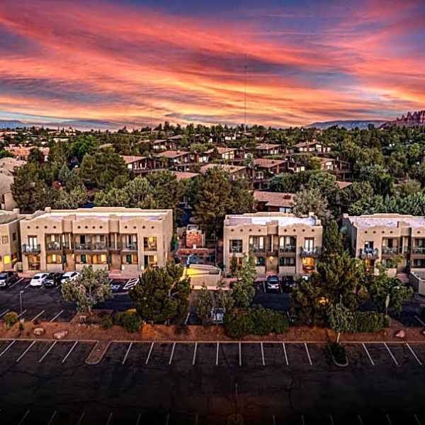 Aerial view of a resort with desert landscape and colorful sunset sky.